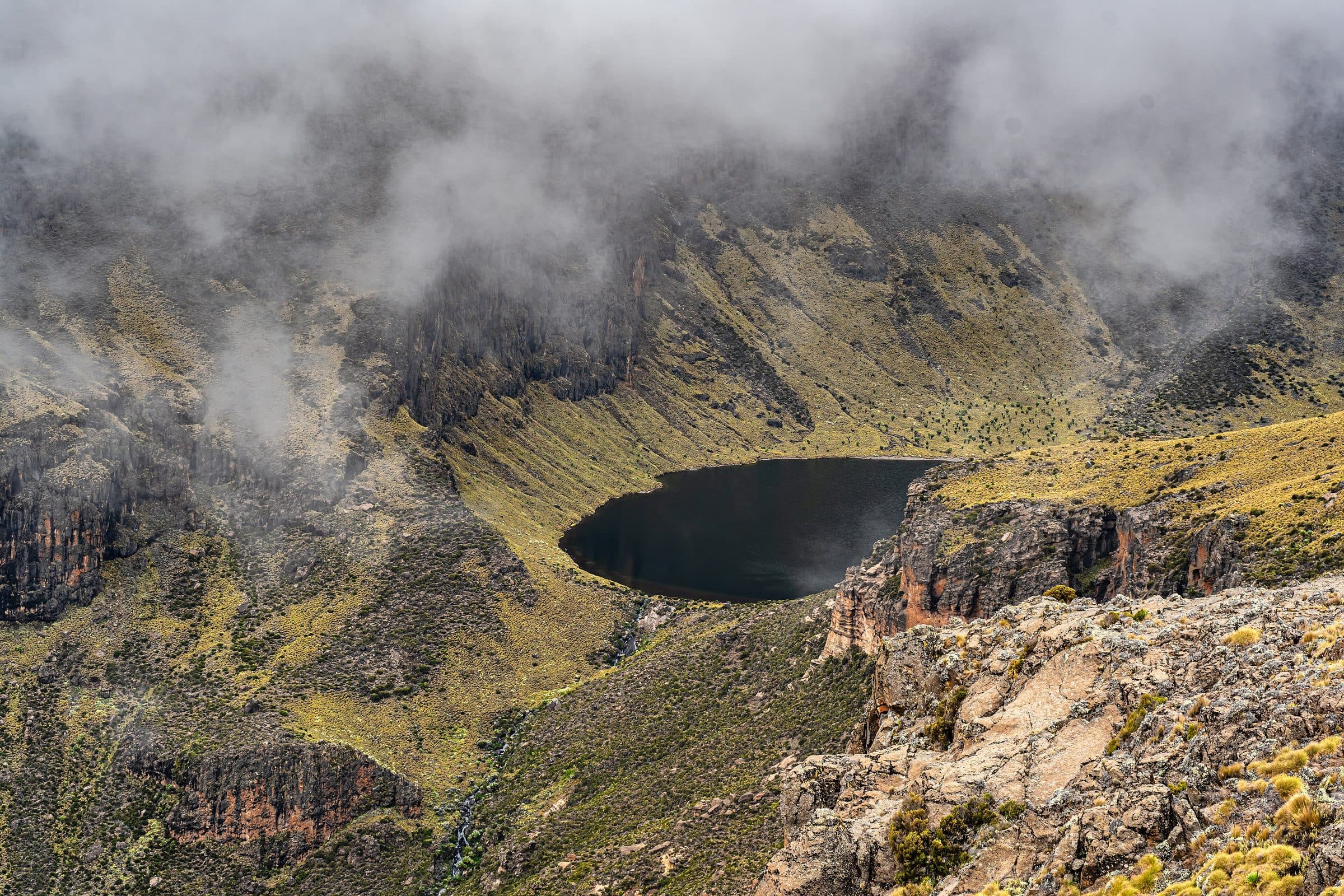 Heart-shaped Lake Michaelson beneath the cliffs of the Gorges Valley, Mount Kenya